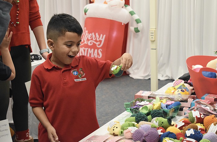 Kindergartener Santiago Perez checks out the crochet items.