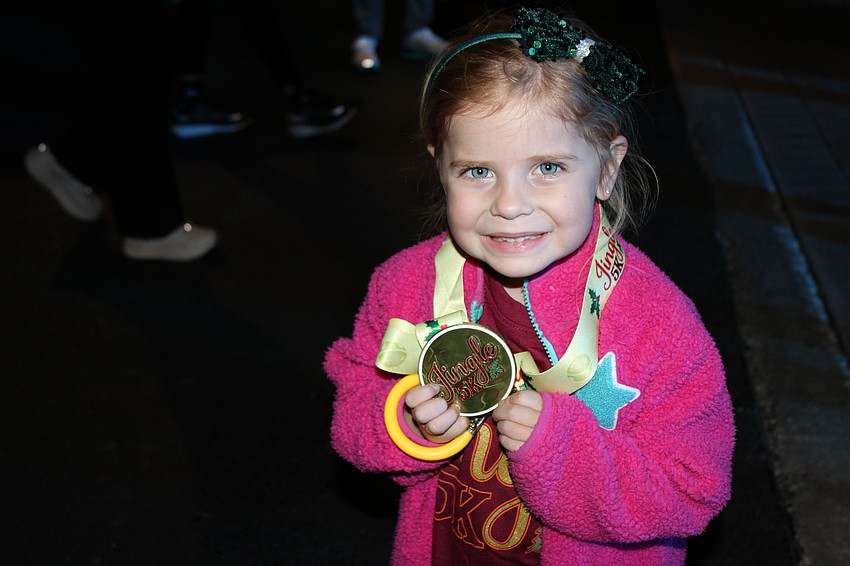 Parrish 4-year-old Ava O'Neil shows off her medal after the kids race at the Jingle 5K Dec. 12 in Lakewood Ranch.