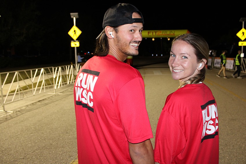Lakewood Ranch's Jacob Wong and Tatum Thornton show off their Willis Smith Construction running shirts before starting the 2025 Jingle 5K in Lakewood Ranch. Wong is a superintendent for Willis Smith.