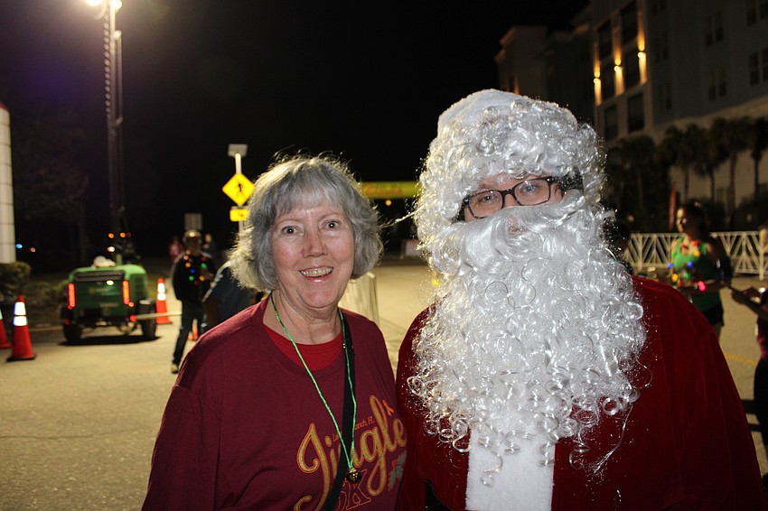 Lakewood Ranch's Erin Petraites chats with Santa (Steven Trudell of St. Petersburg) before the Jingle 5K. She said he planned to walk the 5K.