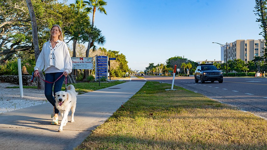 Jen Weekly walks Cooper on the multi-use path parallel to Gulf of Mexico Drive. The town of Longboat Key has adopted a “Complete Streets” plan which envisions wider multi-use paths to accommodate pedestrians and cyclists.