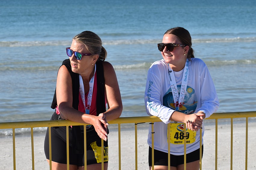 Lisa Sherman and Lily Sherman watch the runners come in for the finish.