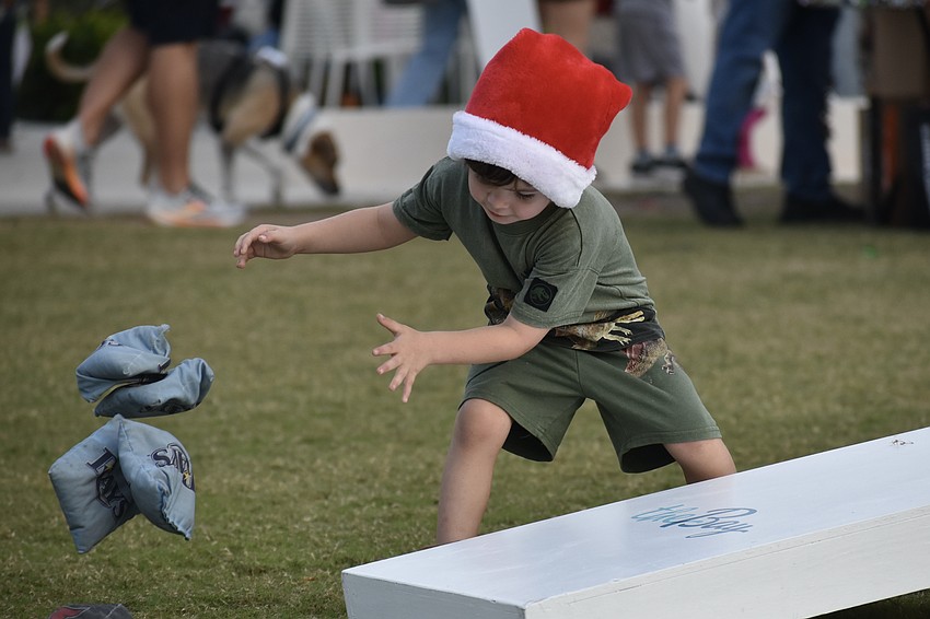 River McMichael, 5, clears the cornhole board to start a round of the game.