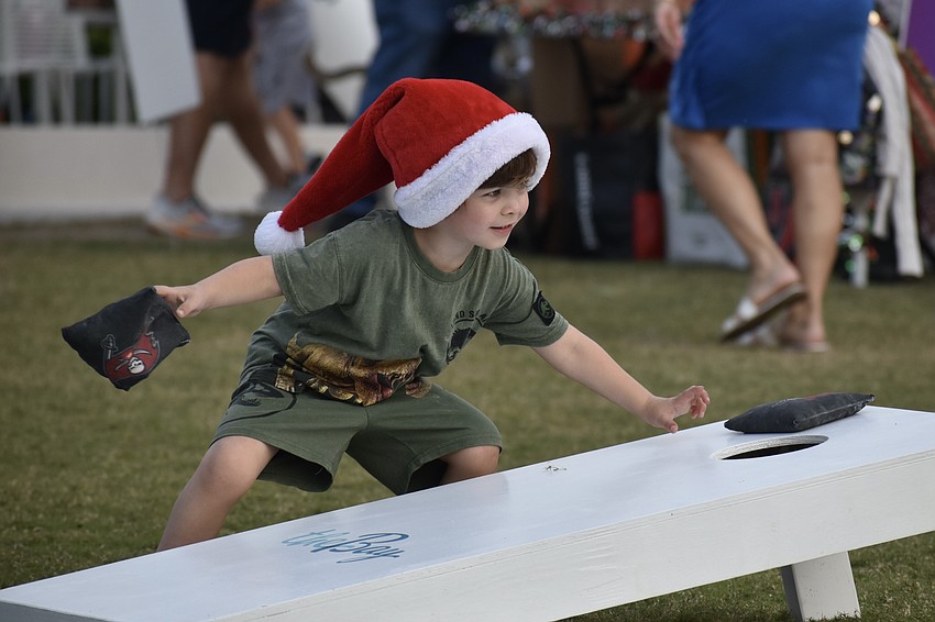 River McMichael, 5, clears the cornhole board to start a round of the game.