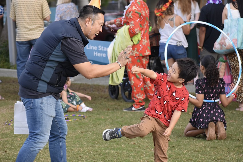Wenxiao Li and his son Eddy Li, 3, exchange a high-five and a kick.