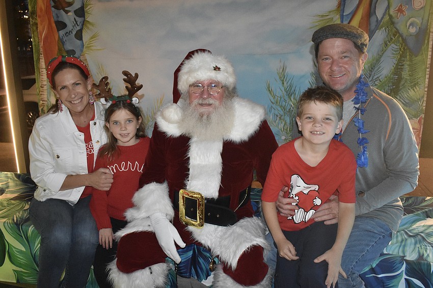 Wendy Egan, Eliana Egan, 5, Santa Claus, Macallister Egan, 7 and Shawn Egan have a seat together.