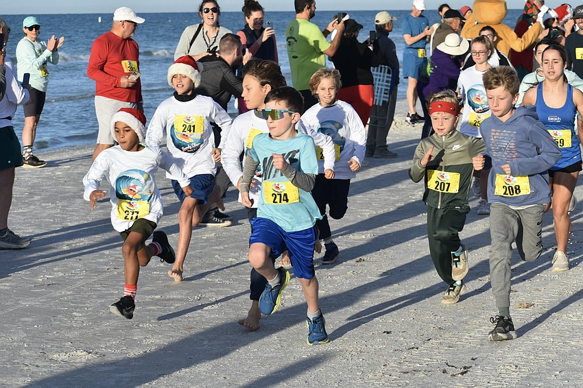 Runners head out on the fun run, with Walter Downing, 7, front-center.