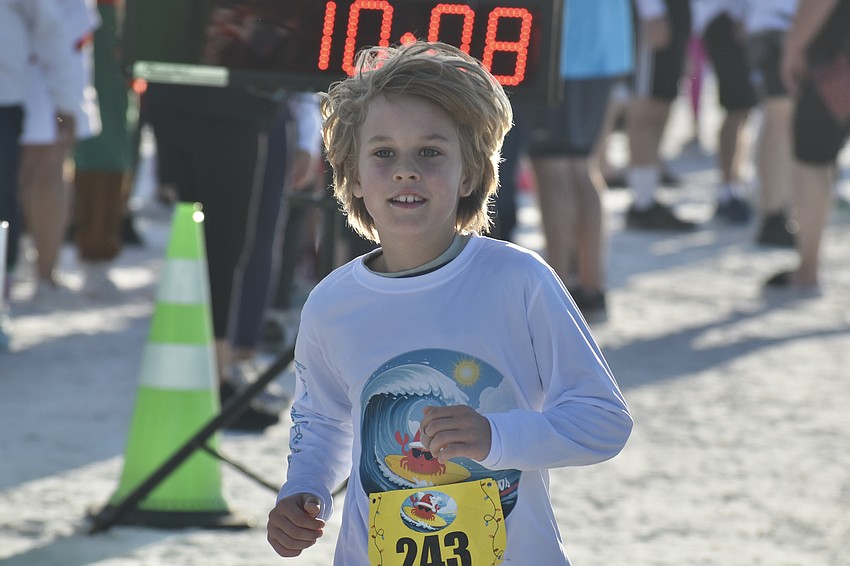 Avi Dorrill, 8, approaches the finish line of the fun run.