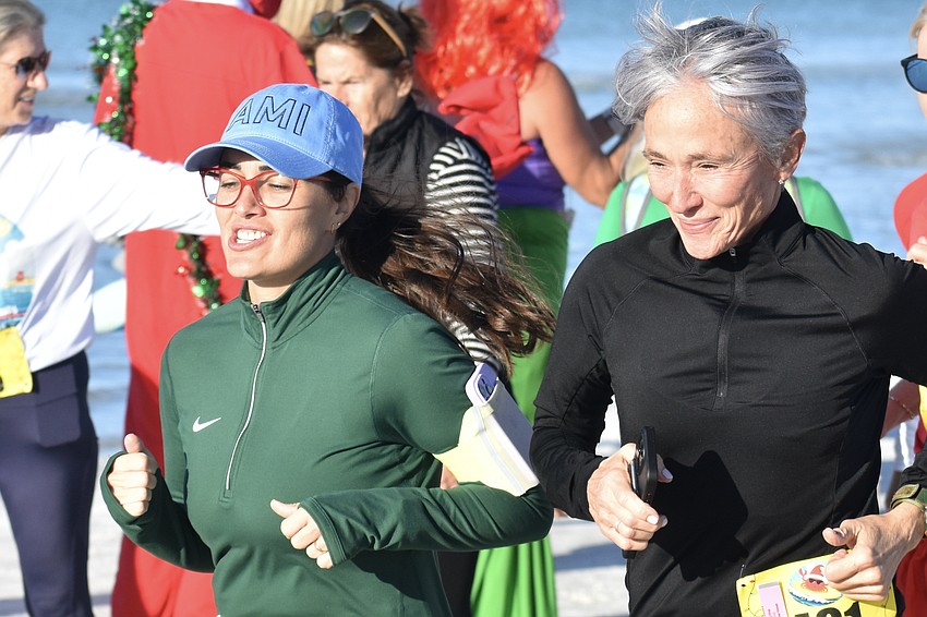 Marina Morelatto and Carol Morris head across the beach.