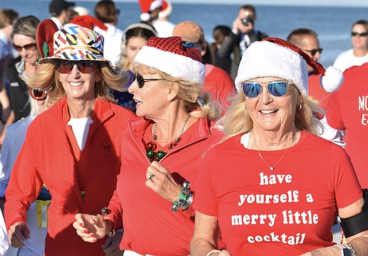 Joni Hill, Cate Douglas and Gaby Hayashi make their way across the beach.