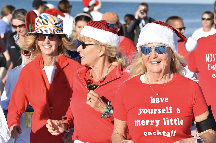 Joni Hill, Cate Douglas and Gaby Hayashi make their way across the beach.