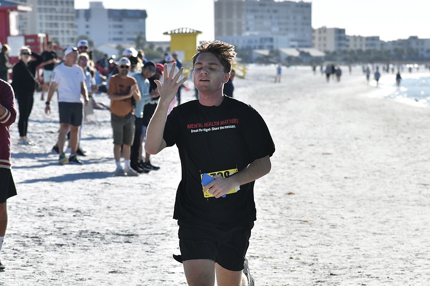 First overall male Declan Fiorucci celebrates his victory as he approaches the finish line.