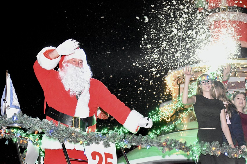 Amid a flurry of snow, Santa Claus and boat passengers wave from Bluewater.
