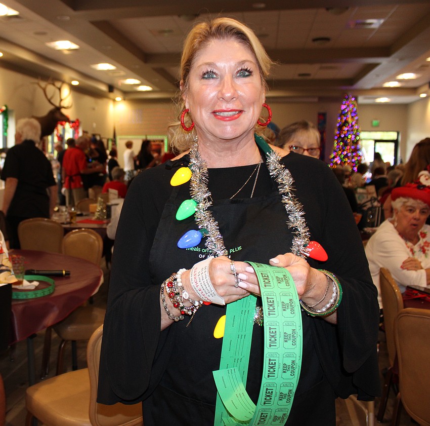Judi Bjork, a former vice president at Meals on Wheels Plus, sells raffle tickets during the event. She remembered the joy she felt in delivering the shoeboxes to seniors.