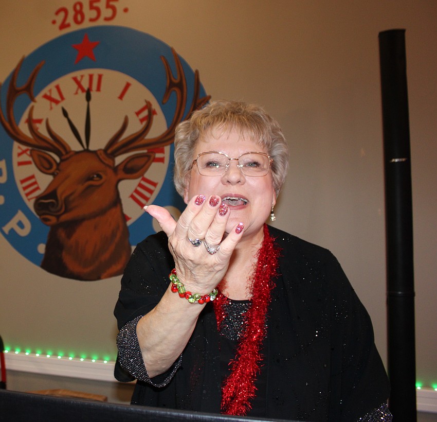 Phyllis Stolteben of Lynns Spins blows a kiss to the crowd during the 20th annual Community Holiday Shoebox Collection Drive and Reception.