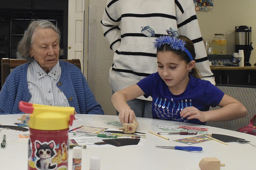 Margaret Taylor plays with the dreidle, with Katelyn Silverstein, 8.