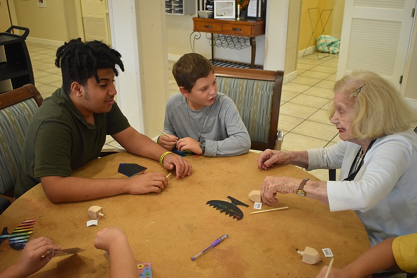 Seventh grader Blake Brown and fourth grader Jacob Berman make dreidels with Edie Geier. Seventh grader Blake Brown and fourth grader Jacob Berman make dreidels with Edie Geier.