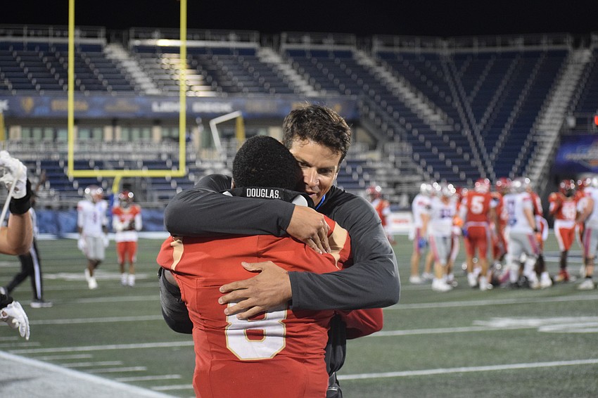 Coach Jared Clark shares an embrace with senior linebacker KJ Brown in the waning seconds of the 2025 FHSAA Class 2A state championship.