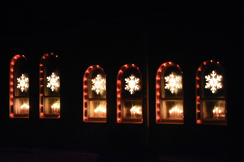 A series of windows includes snowflakes and candles at 3942 Lisbon Place.