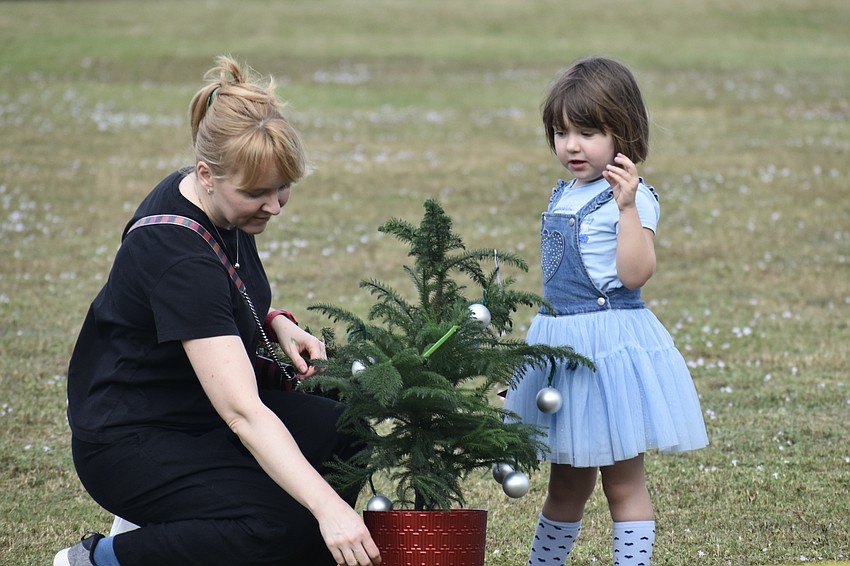 Yulia Mylnikova and Jane Vlasova, 3, take home a small tree.
