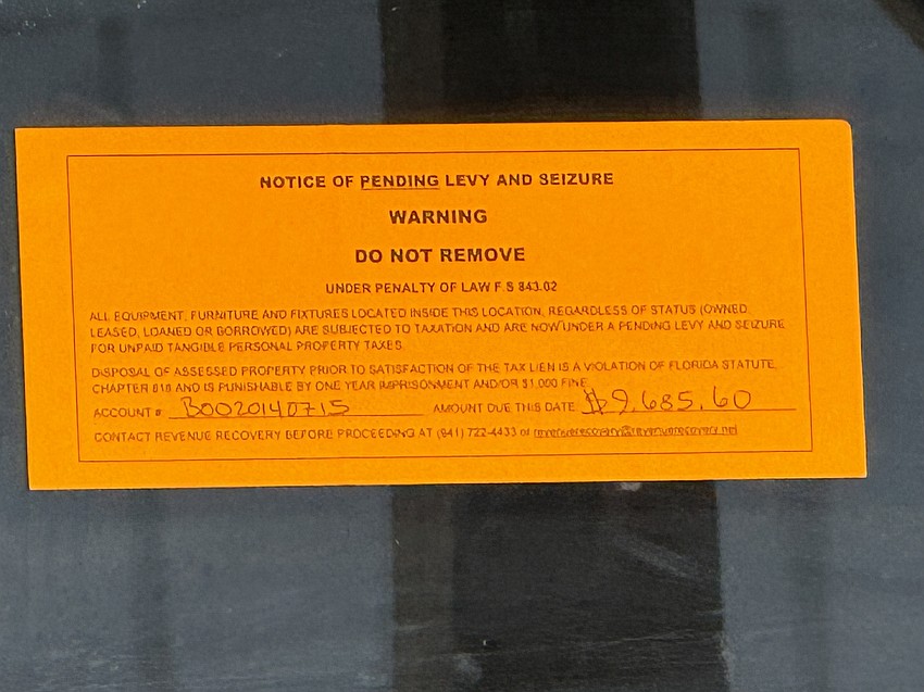 A notice of pending levy and seizure is posted at 975 Cattlemen Road.