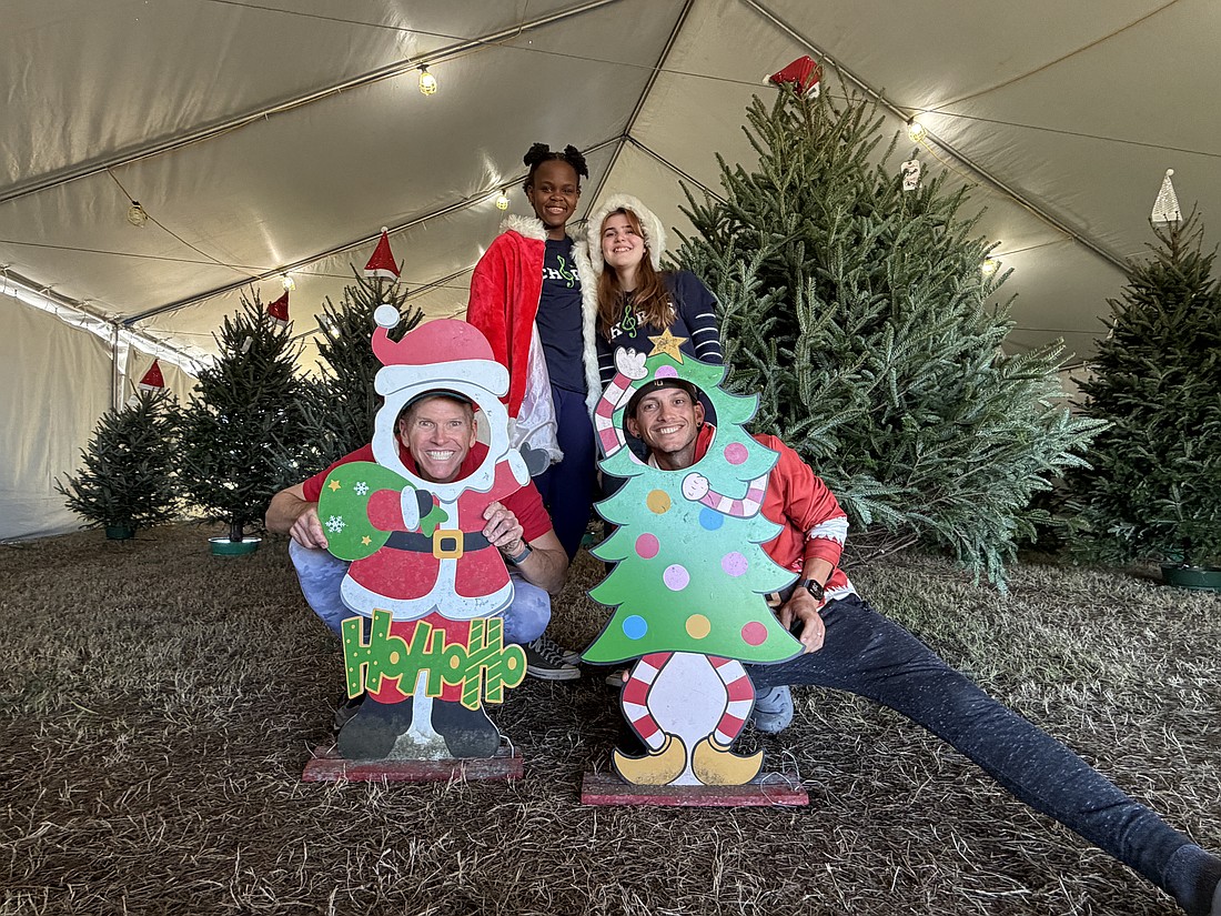 Windermere High School choir students Kemi Agbelusi and Beatriz Bellodi volunteered at the Santa’s Old Fashioned Christmas Tree lot with owner Billy Flanigan and his son Kyle Flanigan. The proceeds from the tree lot support the high school’s choir program.