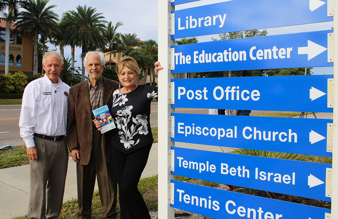 Howard Tipton, Irwin Pastor and Susan Goldfarb stand beside the newly installed sign for The Education Center on Bay Isles Road. The center starts its winter term of programs Jan. 5.