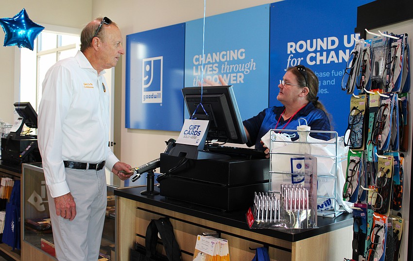 Commissioner Gary Coffin makes the first official purchase from Pru Davis at the new Goodwill book store and donation site on Longboat Key at the Dec. 18 grand opening.