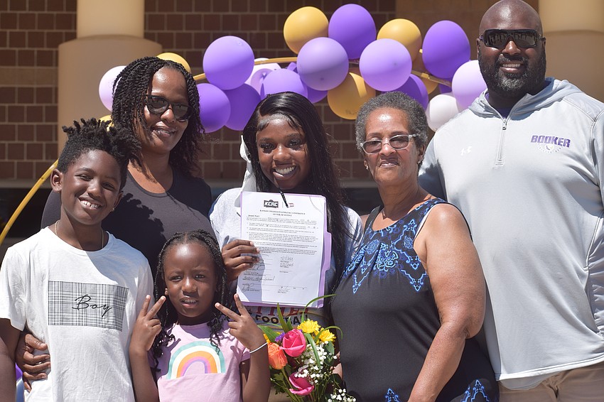 Jewel Kerr poses for a photo with brother Amir Kyles, mother Jacqueline Pearson, sister Kasi Pearson, grandmother Wanda Pearson and coach Carlos Woods. The former senior at Booker made history by committing to Bethel College for flag football.