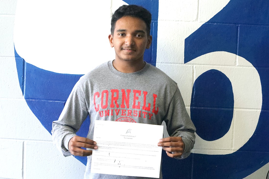 Syed Haider holds up his letter congratulating him as a QuestBridge National Match scholarship selection to Cornell University. Photo by Brent Woronoff
