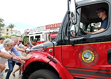 With a hearty collective effort, community members help “push in” the newest fleet addition at Fire Station 92 during a March 25 open house. The public was invited to see the facility, which opened in 2021, as well as check out the station’s new $600,000 ambulance.