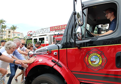 With a hearty collective effort, community members help “push in” the newest fleet addition at Fire Station 92 during a March 25 open house. The public was invited to see the facility, which opened in 2021, as well as check out the station’s new $600,000 ambulance.