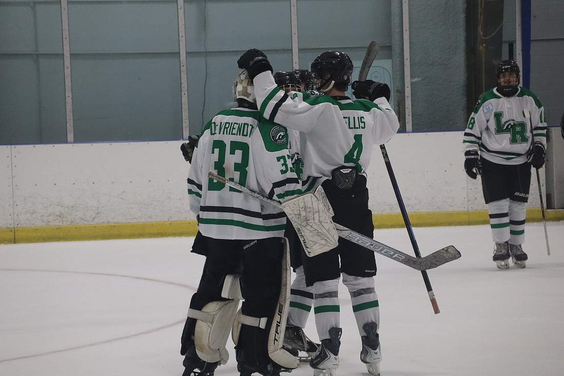Lakewood Ranch junior goaltender James Devriendt (33) gets some postgame kudos from senior defenseman Jackson Ellis (4). Devriendt's .878 save percentage and 2.05 goals against average through 13 games are both career-best marks on a Mustangs team that has done nothing but win in 2025-26.