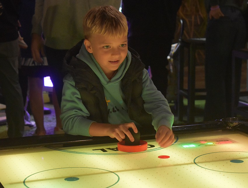 Lakewood Ranch's Daniel Gorr, 7, puts his love for hockey to good use when playing air hockey at the New Year's celebration.