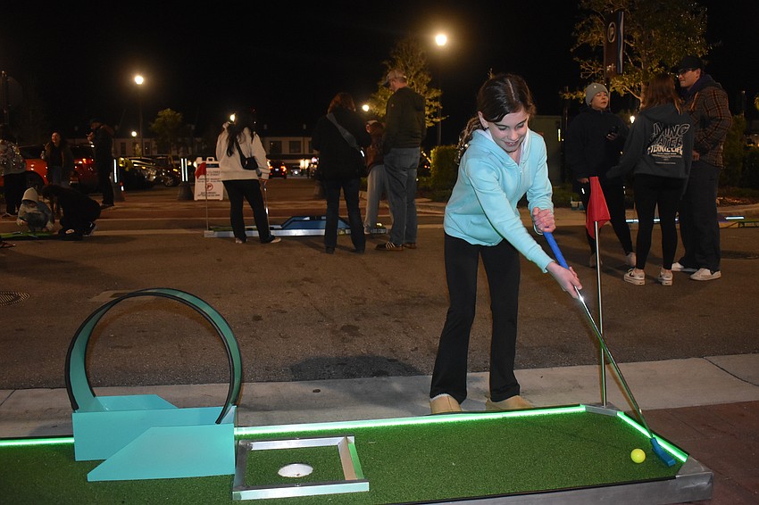Lakewood Ranch's Emmi Riordan, 8, tests out the mobile light up mini golf course.