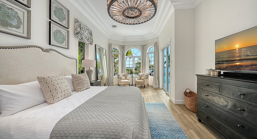 The primary bedroom suite faces the water and features a chandelier of its own.