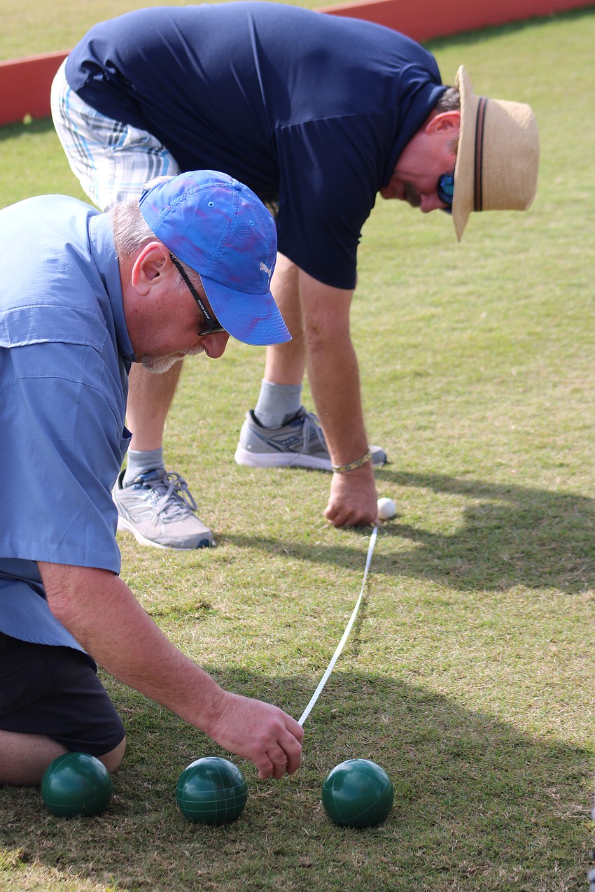 Lakewood Ranch's Tom Trew (front) and Joe Schuller measure which team is closer to scoring in their game of Bocce before polo Jan. 4 at the Sarasota Polo Club.