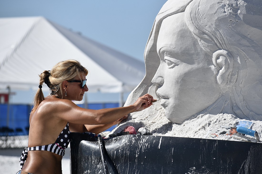 Angese Rudzite Kirillova works on "Playground" during the 2025 Siesta Key Crystal Classic Sandsculpting Festival.