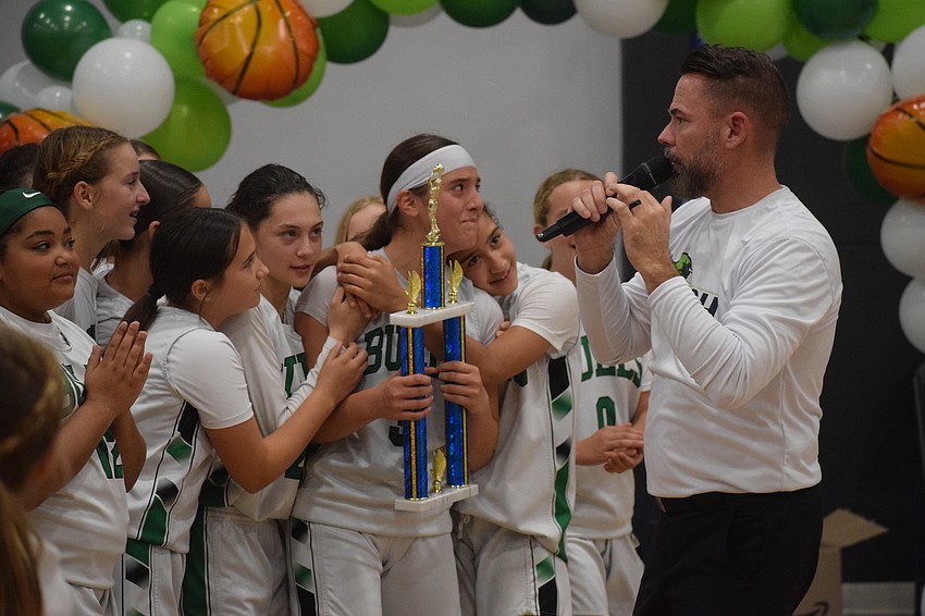 Coach Eric Hoskins (right) speaks to the crowd after handing the Florida Suncoast League championship trophy to Eva Lopes. He has coached her at the middle school level ever since Lopes joined as a sixth-grader. Coach Eric Hoskins (right) speaks to the crowd after handing the Florida Suncoast League championship trophy to Eva Lopes. He has coached her at the middle school level ever since Lopes joined as a sixth-grader.