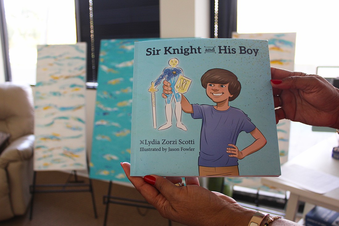 Local author Lydia Zorzi Scotti recently published her first children's book, "Sir Knight and His Boy," held up by local artist Medge Jaspan at the book's local December launch.