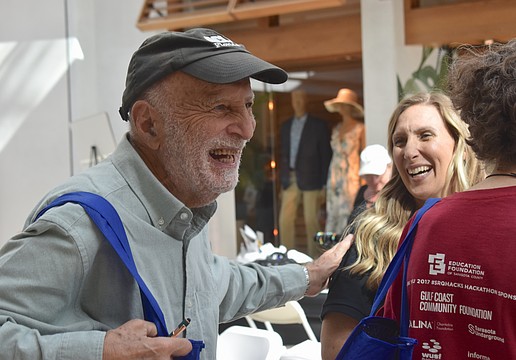 Sarasota's Hasan Tezduyar gives a pat of appreciation to Rachel Apple, a wellness associate with Qualliv, at the Health and Wellness Expo at The Mall at University Town Center.