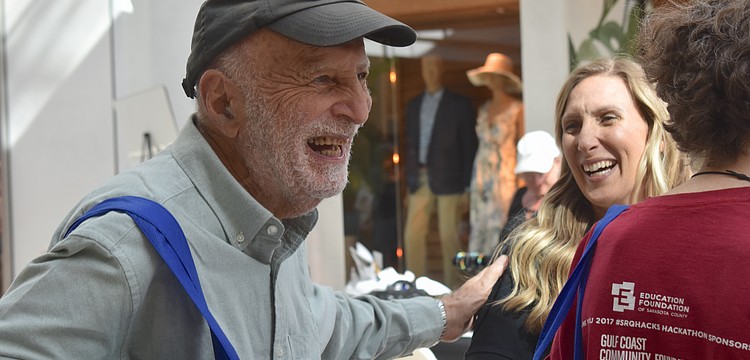 Sarasota's Hasan Tezduyar gives a pat of appreciation to Rachel Apple, a wellness associate with Qualliv, at the Health and Wellness Expo at The Mall at University Town Center.