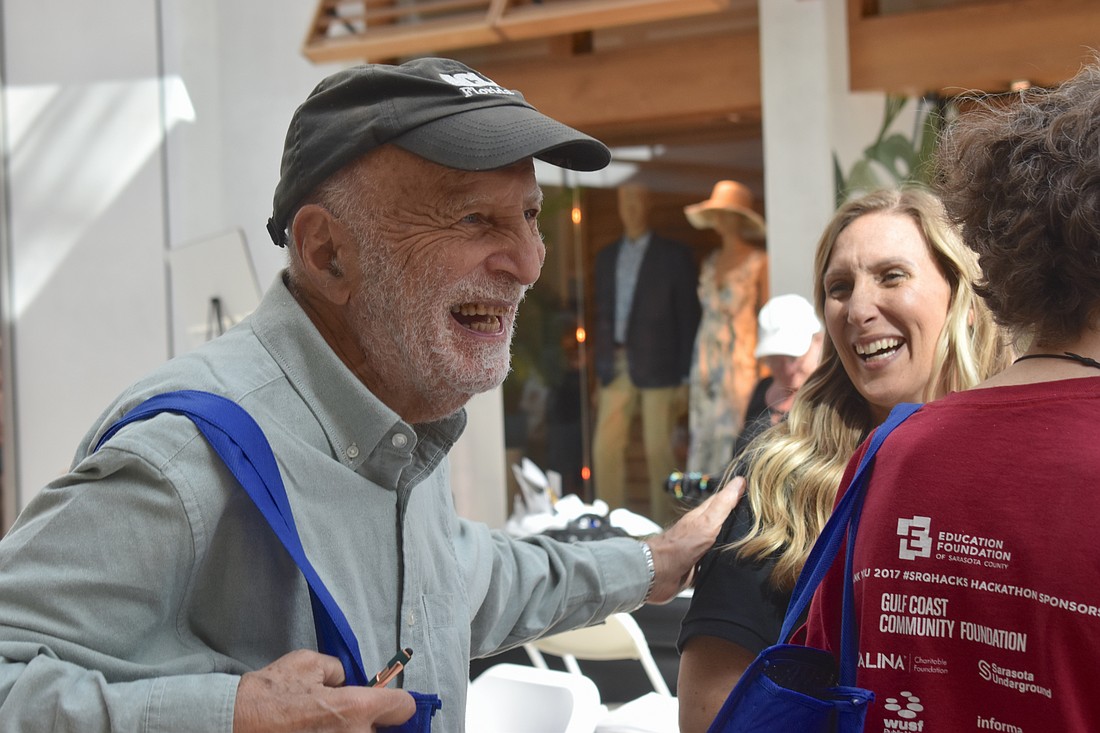 Sarasota's Hasan Tezduyar gives a pat of appreciation to Rachel Apple, a wellness associate with Qualliv, at the Health and Wellness Expo at The Mall at University Town Center.