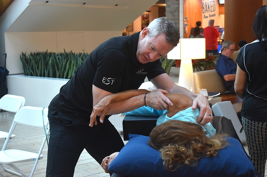Dave Boltz, a massage-mobility specialist, is among the team members from Elite Stretch Therapy who provided free massages to people in The Mall at University Town Center for the health expo.