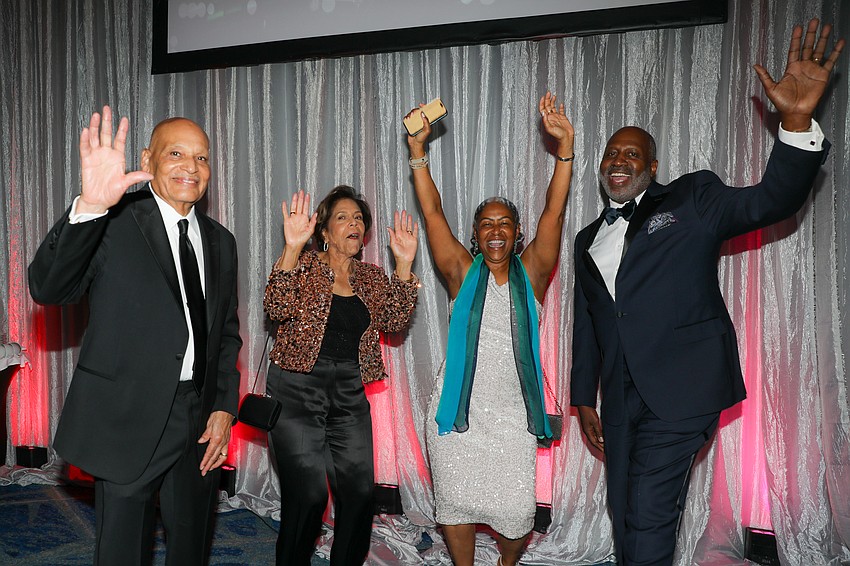 Dr. Cecil Pickett and wife, Shirley, raise the roof with Adela and Tony Glover.