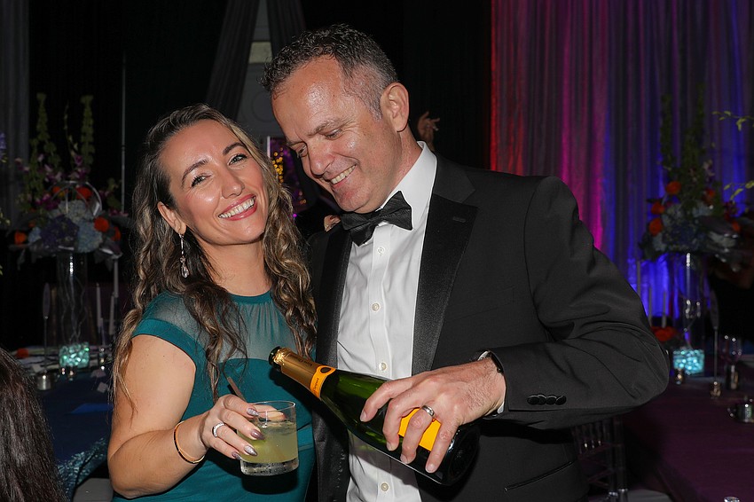 Dr. Kujtim Latifi pours a splash of bubbly for his wife, Erjeta.
