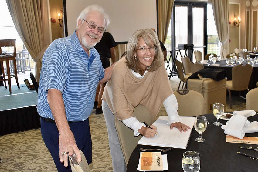 Country Club's Randy Aranowitz gets his book signed by Laura Cole, senior vice president of Lakewood Ranch.