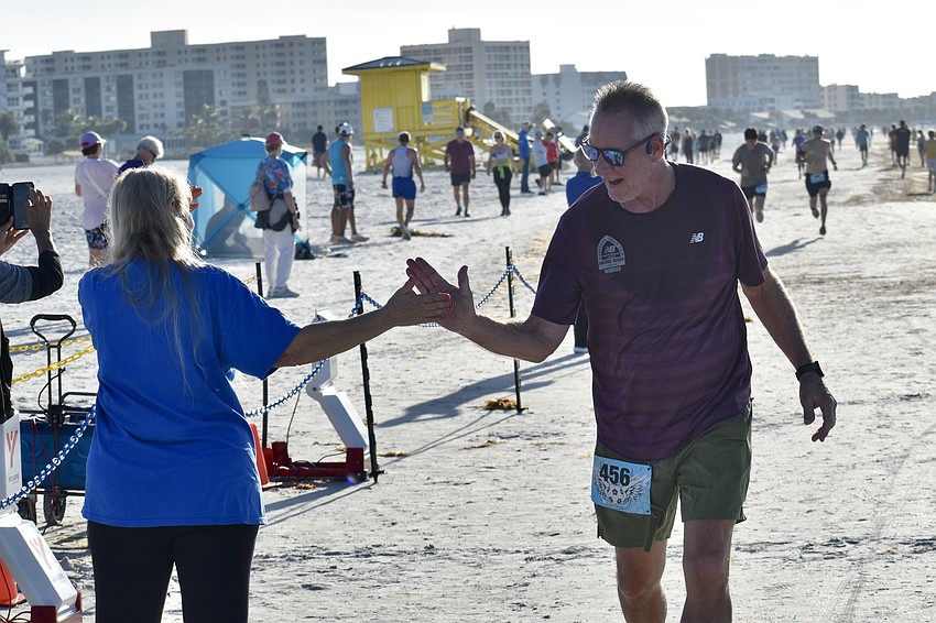 Stacey Monroe slaps hands with Rob Loeffler of Manasota Track Club.