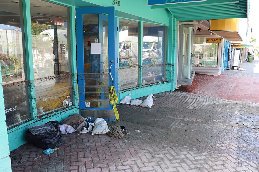 Images of the mud at the waterline of storefronts on St. Armands Circle serve as reminders of the flooding caused by hurricanes Helene and Milton.