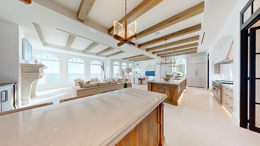 The kitchen has custom cabinetry, quartz countertops and designer lighting.